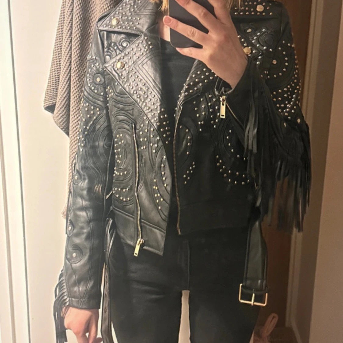 Svart skinnjacka med nitar och fransar