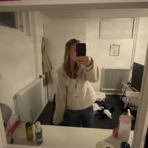 Beige teddyjacka med dragkedja - Mysig beige teddyjacka med dragkedja och stora fickor framtill. Perfekt för kyliga dagar med sin fluffiga och varma design. Jackan har en avslappnad passform och en stor krage som ger extra värme. Säljer den pga att den inte används. Den är svår att hitta och har slutat säljas online