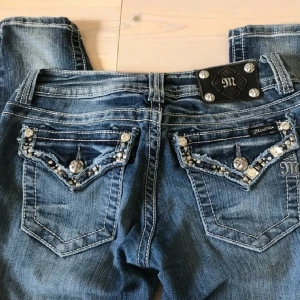 Miss me jeans 💘 - Jätte snygga blå jeans, lågmidjad passform från Miss Me med glittrande strassdetaljer på fickorna. Jeansen har en klassisk femficksdesign och en knappgylf. Passar bra om man har storlek S-M i jeans! Aldrig kommit till användning då de inte passade💓 priset är alltid diskuterbart. Första & sista bilden visar färgen på jeansen mer korrekt. Skickar även iväg paket samma dag eller dagen efter 🫶🏼 