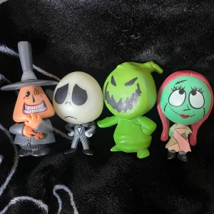 Nightmare before Christmas  - Fyra figurer från en populär animerad film. De har unika utseenden: en gråklädd figur med två ansikten, en svartvit randig figur, en grön figur med ett brett leende och en grön figur med rött hår och en lappad klänning. Jätte bra skick men Sally saknar en arm annars bra! 30kr styck köp alla för 100 🩷