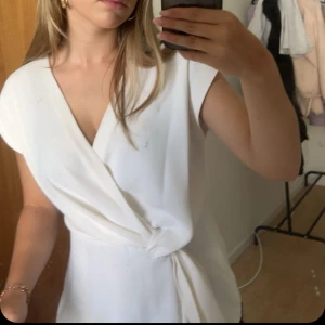 Vit omlottopp - Snygg vit omlottopp med korta ärmar och knytning i sidan. Perfekt för en sommar dag men passar bra nu i vinter med. Säljs då den inte har kommit till andvändning. Som ny. Kom gärna med pris förslag och hör av er vid fråger!💕