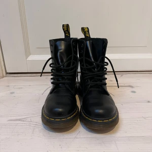 Dr. Martens 1460 boots svarta, stl 36  - Svarta klassiska Dr. Martens boots i skinn med klassisk snörning och gul söm längs sulan i stl 36.