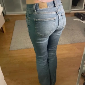 Blå jeans med bootcut - Snygga blå jeans med bootcut och låg midja. Perfekta för en avslappnad stil. Klassisk femficksdesign och knappgylf.