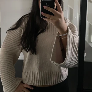 Beige stickad tröja från Gina Tricot - Mysig beige stickad tröja från Gina Tricot med ribbade detaljer. Perfekt för kyliga dagar med sin bekväma passform och långa ärmar. En stilren och enkel design som passar till många tillfällen. Tröjan är endast andvänd en gång, där av priset. Säljer då jag inte får användning av den. 