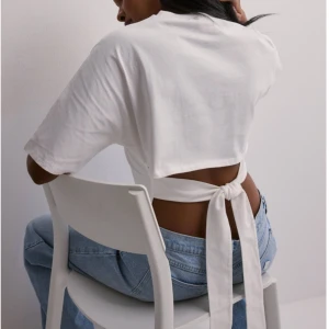 T-shirt med knytning  - Säljer denna slutsålda och trendiga topp från Nelly som endast är testad! 