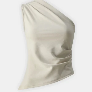 Beige oneshoulder topp - Säljer en snygg beige oneshoulder topp. Perfekt för sommarens fester eller en utekväll.