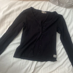 Långärmad tröja med knappar - Långärmad svart tröja med knappar