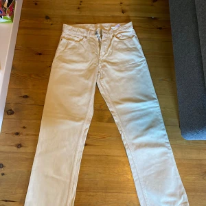Beige chinos - Säljer ett par snygga beige Jeans. De är i bra skick och perfekta för både vardag och lite finare tillfällen. Byxorna har en liten bredare passform och är tillverkade i bomull, vilket gör dem bekväma att ha på sig hela dagen. De har en klassisk desig