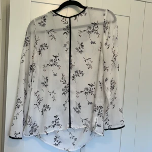 Vit blus - Vit blus med blommigt mönster i blått