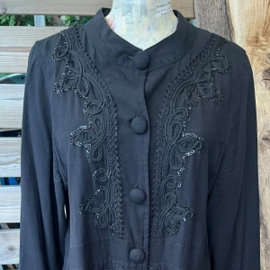 Vacker kappa i linne med brodyr  - Så vacker! I linne med vacker dekor av pärlor/paljetter. Fickor med lock i sidorna. Klädda knappar. Stl M. Finns ngn pärla som är lite lös, men det syns endast vid nära granskning.