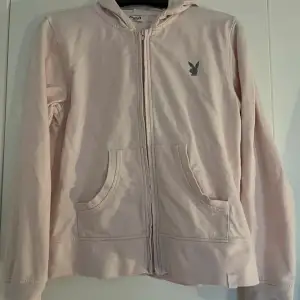 Säljer en ljusrosa zip up hoodie från Playboy Basics. Den har en liten Playboy-logga på bröstet och text bak🔥🔥