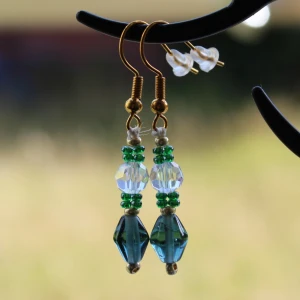 Färgglada örhängen med pärlor - Säljer ett par superfina örhängen med pärlor i olika färger. De har en mix av gröna, blå och genomskinliga pärlor som ger en härlig färgkombination. Perfekta för att liva upp vilken outfit som helst! 💚💙✨