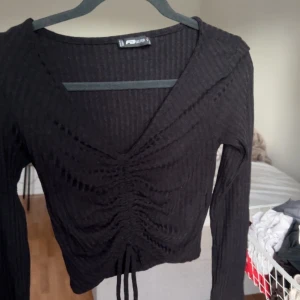 En svart tröja - Tunn svart tröja med en knut 