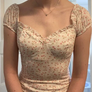 Blommig topp - Söt blommig topp från Nelly. Går att ha på axlarna eller off shoulder. I fint skick. 