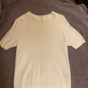 Vit stickad tröja från Sfera Basic - Säljer en snygg vit stickad tröja från Sfera Basic. Tröjan har ett fint mönster och korta ärmar. Perfekt för både vardag och fest! ❤️