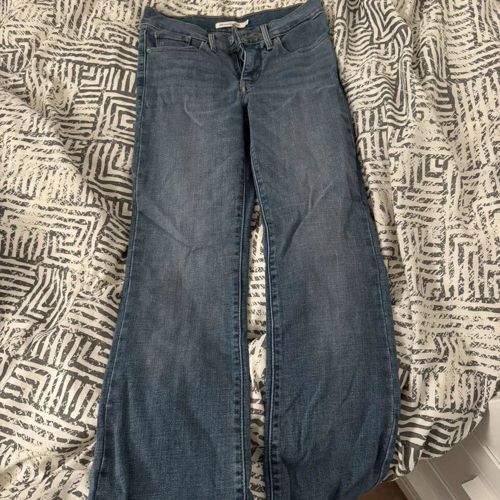 Säljer ett par Levi's 315 Shaping Bootcut jeans i storlek 25. De är i en klassisk blå färg och har en bootcut-stil som ger en snygg siluett. Jeansen är i bra skick och har en hög midja som ger en bekväm passform. Perfekta för både vardag och fest!. Jeans & Byxor.