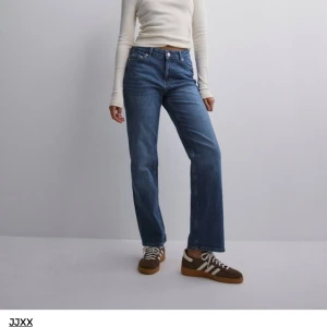 Blå jeans från JJXX - Säljer ett par snygga blå jeans från JJXX. De är högmidjade och har en straight fit som ger en klassisk look. Jeansen är tillverkade i ett slitstarkt denim-material och har en knapp- och dragkedjestängning. Perfekta för både vardag och fest! Köpta på nelly för 599kr