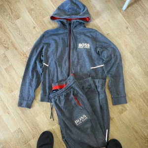 Hugo boss Tracksuit limited edition - Nypris 3800kr!! Hugo boss Tracksuit/dress i bra skick! Köpt för cirka 5 år sen inga fläckar bara hålet vid snöret på byxan har töjts ut men inget som syns kan skicka bild. Tröjan är storlek M och byxorna L. Säljer bara hela tracksuiten. 