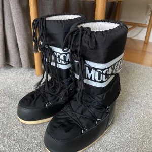 Svarta Moon Boots i nyskick - Säljer ett par svarta Moon Boots som är i nyskick, använda endast ett fåtal gånger! Storlek 39/41, kvinna. 