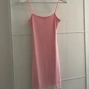 Säljer en söt rosa klänning från H&M. Den är ärmlös med smala axelband och har en fin volangdetalj vid halsringningen. Klänningen är i ett mjukt och bekvämt material, perfekt för sommardagar. Den är i nyskick och redo för nya äventyr! 🌸