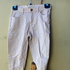 Beige skinny fit byxor från H&M - Säljer ett par snygga beige skinny fit byxor från H&M. De har en klassisk femficksdesign och en knapp i midjan. Perfekta för en stilren vardagslook!