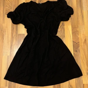 Svart V-ringad klänning  - En kortare klänning, går att styla den på så många olika sätt! 