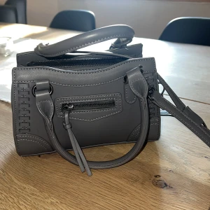 Väska  - Säljer denna väska från Gina då jag inte använder den, den är i jättefint skick och inte använd så mycket. Har både två korta band och ett långt. Nypris 400kr