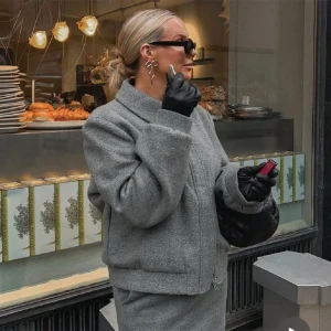 Lojsan Wallin x NA-KD - Grå bomberjacka i ullblandning från Lojsan Wallins kollektion med NA-KD. Helt ny med prislapp. Den här bomberjackan har ett foder och en texturerad känsla. Den har en oversized passform och en dragkedje- och knappstängning. Perfekt höstjacka, storlek