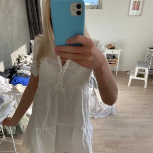 Vit miniklänning från zara - En jättefin vit miniklänning från zara som inte säljs längre. Aldrig använd men ingen lapp kvar. Har en liten liten smink fläck på en av knapparna som ni kan se på sista bilden men det syns inte när klänning är på💓 