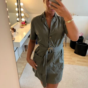 Camo miniklänning - Snygg kort camofärgad klänning med knytband i midjan och fickor.