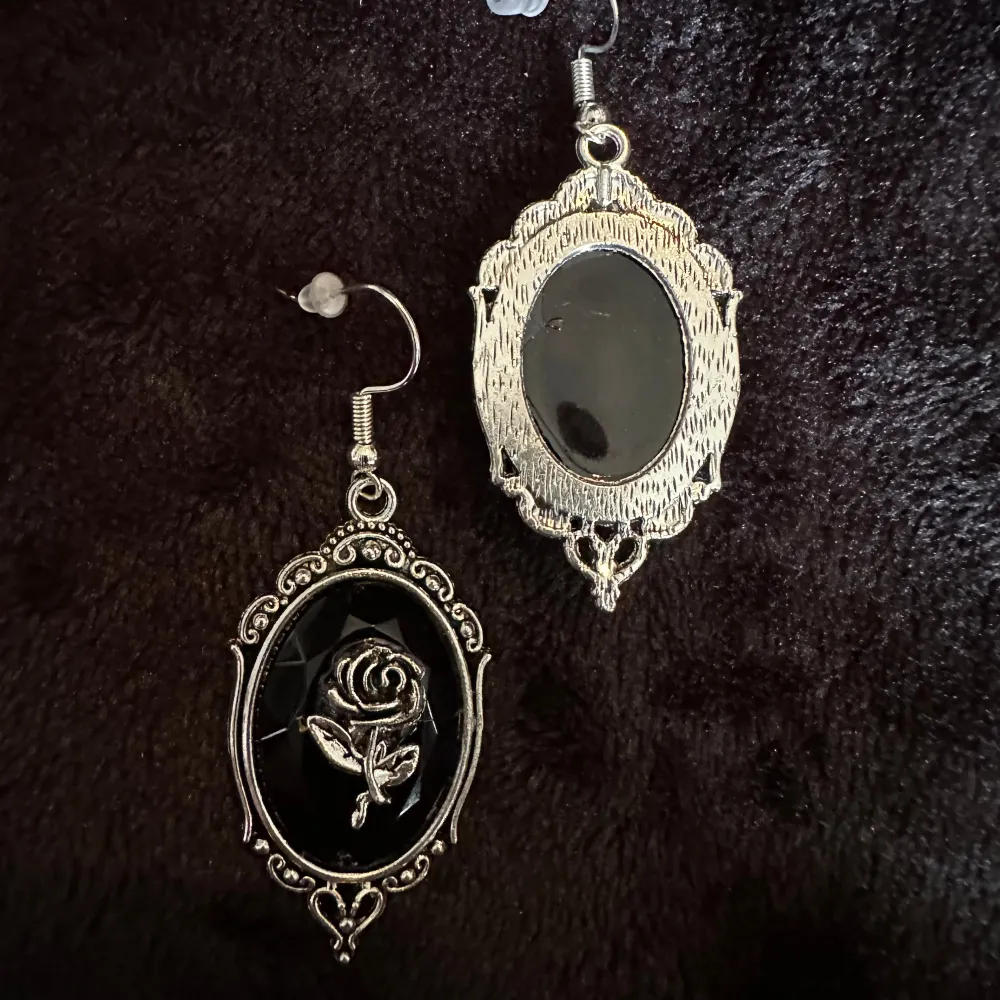 Säljer ett par nya eleganta romantiska svarta örhängen vackra rosor i silver. Den svarta bakgrunden är fasettslipad och glittrande. De har en vintagekänsla med en oval form och intrikata mönster runt kanterna. Hypoallergena krokar, längd 6,2 cm.. Accessoarer.