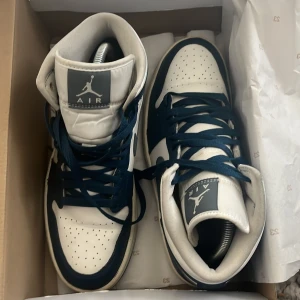 Jordan Air - Säljer ett par snygga Nike Air Jordans i blått och vitt. Skorna har en klassisk design med snörning och den ikoniska Air Jordan-loggan på plösen. De är i bra skick och perfekta för både vardag och fest. Passar dig som vill ha en stilren och sportiga 
