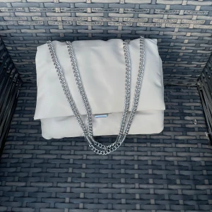 Axelremsväska - Creme-färgad axelremsväska från H&M.