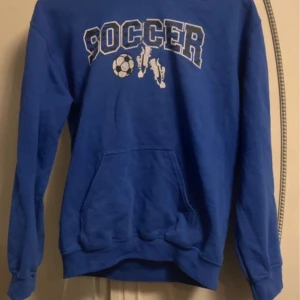 Blå Soccer Hoodie  - Skön hoodie med najs passform. Skyddar mot vind men är ändå sval, bra att träna i under vår och höst. Har använt den en del men inga synliga tecken på slitage. 
