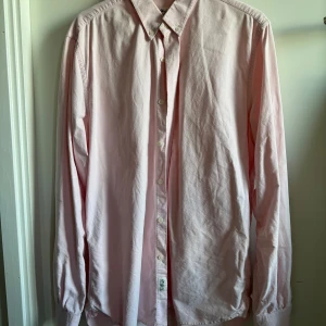 Ljusrosa skjorta från Made in the Shade - Säljer en stilren ljusrosa skjorta från Made in the Shade i storlek L. Tjockare bomullstyg. Endast använd en gång. 