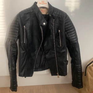 Skinnjacka  - Svart skinnjacka från Chiquelle med många fina detaljer. Den har använts ca 5 gånger så skicket är som ny. Säljer då den inte kommer till användning. Storlek 42 (den är liten i storleken) slutsåld på hemsidan!!!