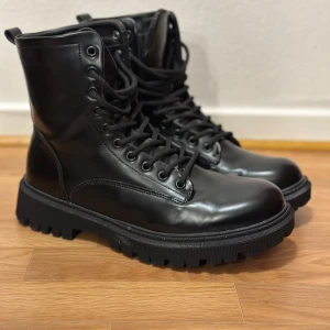 Svarta boots med snörning - Snygga svarta boots i skinn med robust snörning och grov sula. Perfekta för en stilren look och passar bra till både jeans och kappa.