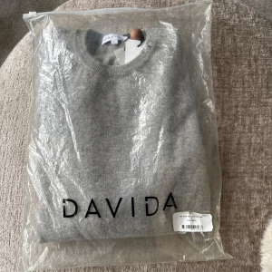 Ljusgrå o-neck Davida - Säljer nu en helt ny ljusgrå o-neck från Davida i 100% cashmere då julklappen blev fel och ej kunde returneras! Tröjan är aldrig använd och nypriset på tröjan är 2599kr. Kan skicka överallt och hör gärna av dig vid ev frågor!