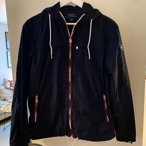 Marinblå vindjacka från Ralph Lauren - Marinblå jacka från Ralph Lauren. Skick 9/10. Storlek S/170/92A. Inköpt på NK Stockholm. Fler bilder finns! 