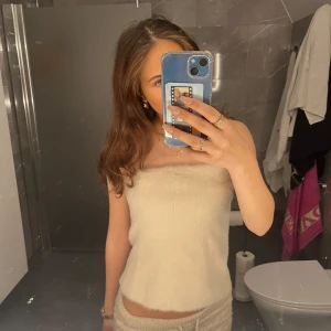 Beige tubtopp - Säljer en stilren beige tubtopp i mjukt material. Dragkedjan på ryggen som gör den lätt att ta på sig! I nyskick💓💓