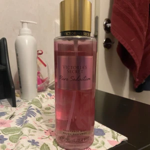 Victoria's Secret Pure Seduction Fragrance Mist - 🩵Säljer en Victoria's Secret Pure Seduction Fragrance Mist. Flaskan är rosa med en gyllene kork och rymmer 250 ml. Doften är fruktig och blommig, perfekt för en fräsch känsla hela dagen. Ni ser hur mkt de kvar av den, knappt använd🩵