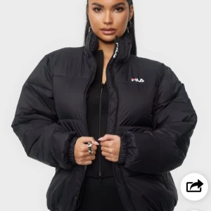 Svart pufferjacka från FILA - Säljer en svart pufferjacka från FILA med dragkedja och hög krage. Jackan har en broderad logotyp på bröstet och är perfekt för kyligare dagar. Den har en normal passform och är långärmad. Använd men fortfarande hel och i bra skick! 