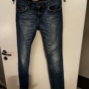 Blå jeans från Denim 40s - Snygga blå jeans från Denim 40s med en klassisk femficksdesign. De har en knappgylf och är perfekta för en avslappnad stil. Jeansen har en lätt tvättad look som ger dem en cool vibe.