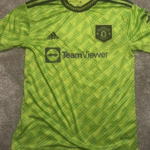 Grön Manchester United fotbollströja från Adidas - Säljer en grön Manchester United fotbollströja. och Rashford 10 på baksidan. Den är i storlek S och har använd den 1 gång så den är i toppskick 