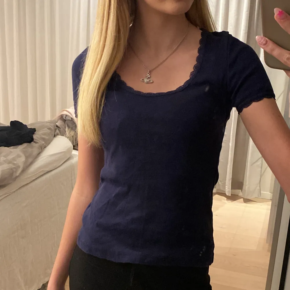 Säljer en mörkblå topp från & Other Stories med spetsdetaljer vid halsringning och ärmslut och små hjärtan. Toppen har korta ärmar och en rundad hals. Perfekt för en stilren look. . T-paidat.