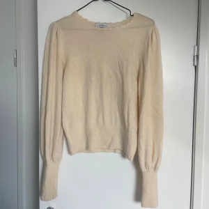 Vit stickad tröja från &otherstories - Säljer en stilren vit tröja från &otherstories med ribbade muddar och mönster i halsringningen. Bra skick och enkel att matcha med olika outfits.