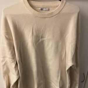 Beige tröja från Zara - Säljer en stilren beige tröja från Zara. Tröjan har en rund halsringning och långa ärmar, perfekt för en avslappnad look. Materialet känns mjukt och bekvämt mot huden.