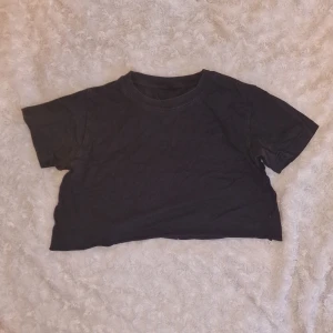 Avklippt/croppad t-shirt - Avklippt/croppad svart t-shirt, liten i storleken.