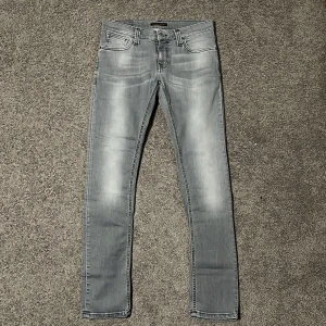 Nudie Jeans - Säljer nu ett par gråa Nudie jeans i storlek 28 som även passar 29 för endast 399kr! Storlek W30/L32 passar mer som W28-29/L30