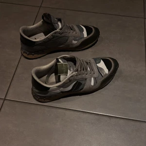 Camouflage sneakers från Valentino - Snygga sneakers från Valentino med ett coolt camouflagemönster i grått och svart. Skorna är i fint skick och är perfekt nu till vinter och höst